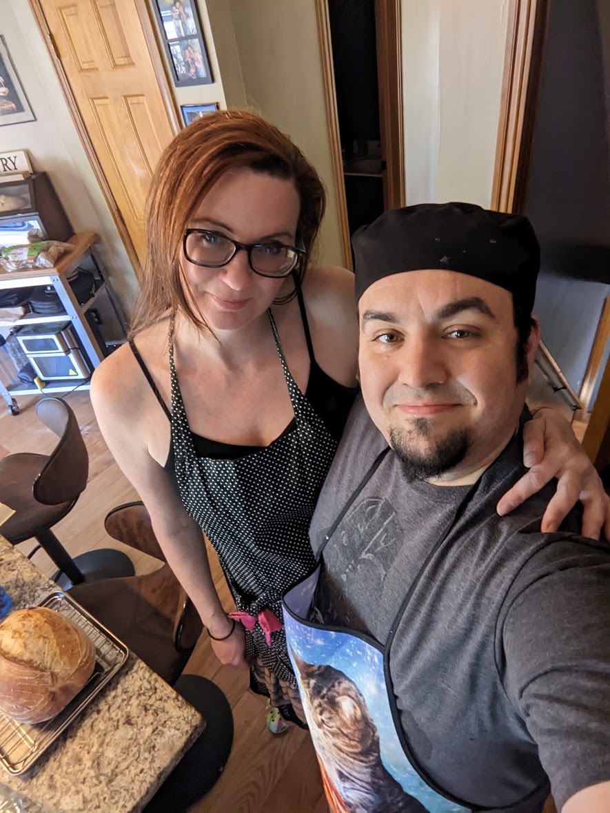 Rachel and Allen in the kitchen, a finished loaf cooling on a rack beside them