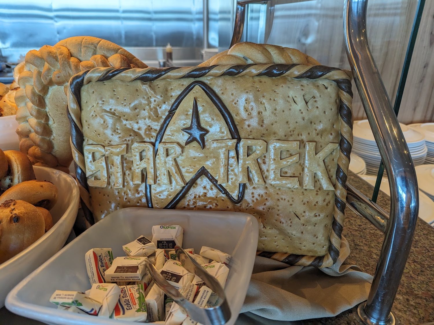 A large bread showpiece sculpted with the Star Trek insignia and lettering, on a buffet